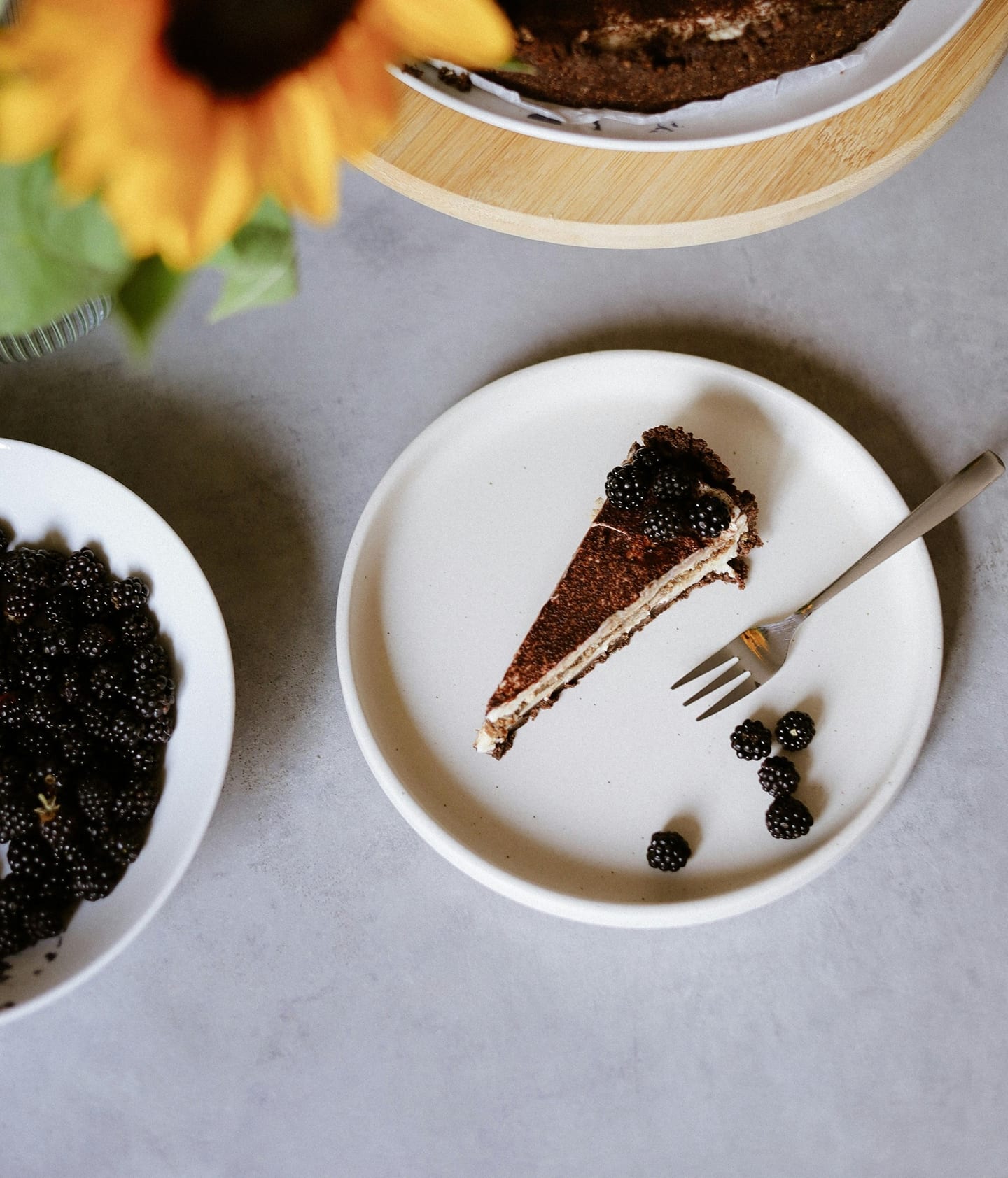 Ein Stück Schokoladentarte mit Brombeeren auf einem weißen Teller