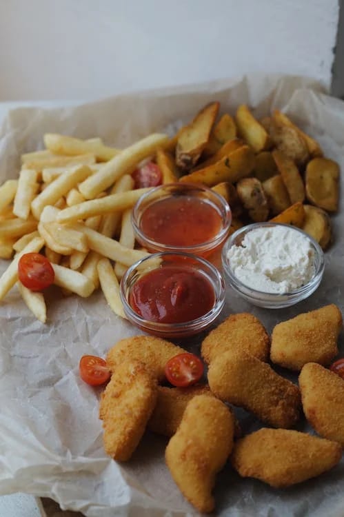 Pommes, Kartoffelspalten und Chicken Nuggets mit Dips